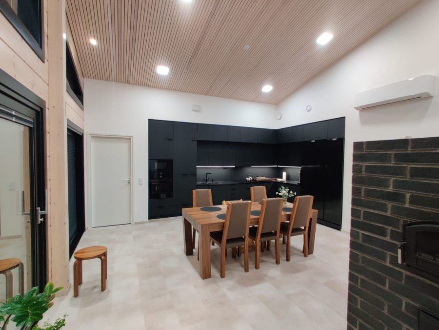 Valkoisten seinien ympäröimänä musta keittiö on tyylikkään linjakas.